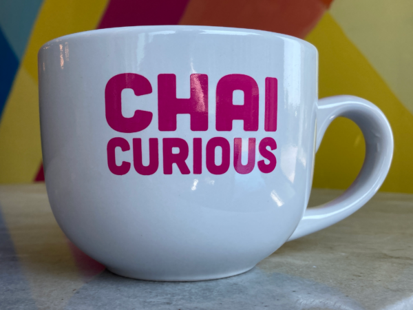 White mug with pink font - chai curious